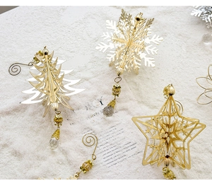 Detail of golden hollow metal Christmas pendants with snowflakes stars and crystal beads