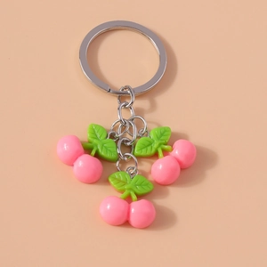 Detail shot of a pink cherry keychain with metal ring and glossy fruit pendants