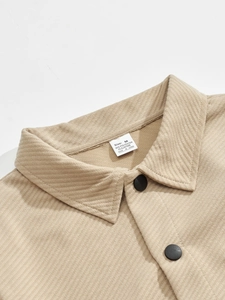 Macro view showing the lapel collar and matte black buttons on the beige twill jacket