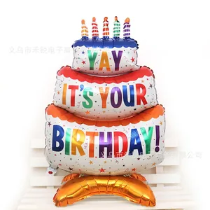 Three-layer birthday cake foil balloon with colorful candles and cloud base on a bench