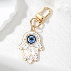Detail of Hamsa Hand keychain with blue evil eye, white enamel, and sparkling rhinestones