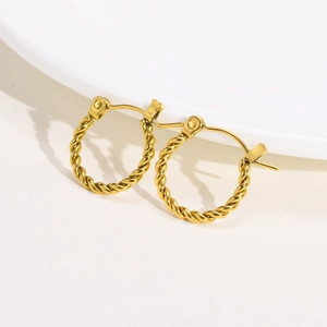 Detailed close-up of golden twisted rope earrings with high-quality polished metal texture