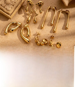 Detailed look at gold plated liquid metal earrings with organic irregular shapes