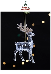 Macro detail of transparent acrylic reindeer ornament with golden glitter antlers for Xmas