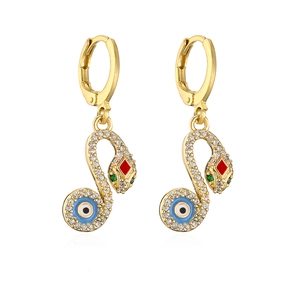 Gold-plated snake hoop earrings with zircon and evil eye charm on white background