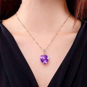Model wearing a purple heart-shaped amethyst pendant with a rose gold chain on a black dress