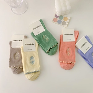 Pastel combed cotton socks with floral embroidery and ruffle trim in diverse colors