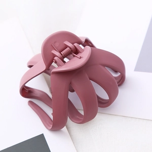 Detail view of large matte octopus hair claw clip in dusty rose with strong metal spring