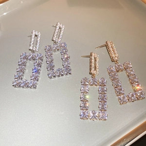 Detailed view of silver and gold geometric square earrings with sparkling cubic zirconia