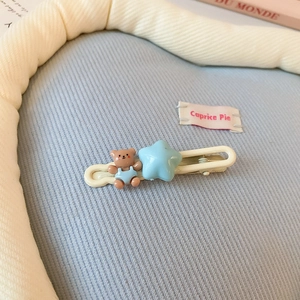 Détail d'une barrette blanc crème avec un ours 3D marron et une étoile bleu clair