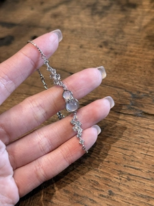 Close-up of a silver bow gourd bracelet with zircon inlay and translucent gemstones