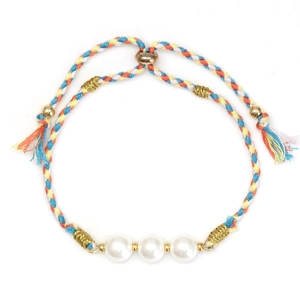 Detailed shot of green braided bracelet with white glass pearls and gold charms