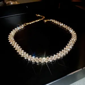 Three-row rhinestone choker necklace in gold finish displayed in a black jewelry box