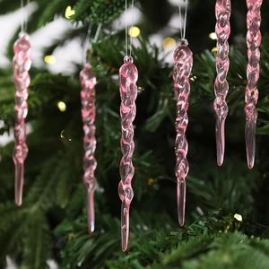 Detailed view of a pink spiral icicle ornament hanging on a festive Christmas tree branch