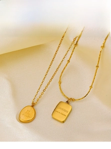 Detail of 18K gold plated stainless steel necklaces with rectangle and oval charm pendants