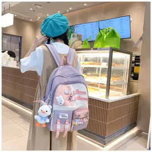 Detail of color-block school backpack with cute rabbit patches and duck keychain