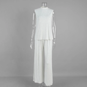 Detail of light gray knitted two-piece set featuring sleeveless top and wide-leg trousers