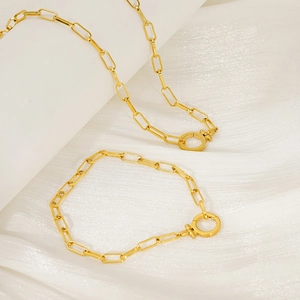 Detail of 18K gold-plated paperclip chain necklace and bracelet with round toggle clasp
