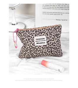 Beauty case leopardato con cerniera rosa e catena di perline su raso bianco lucido