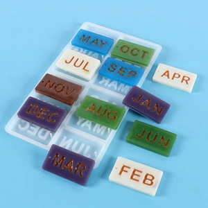 Macro detail of silicone mold and resin charms featuring calendar months abbreviations