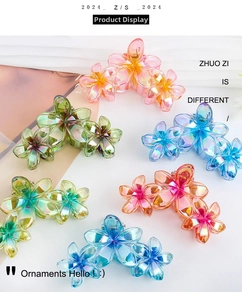 Detailed view of colorful gradient floral hair claws with pearlescent finish on a desk