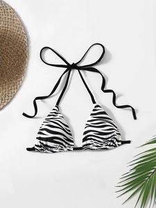 Detailed view of halter triangle bikini top featuring bold black and white zebra patterns