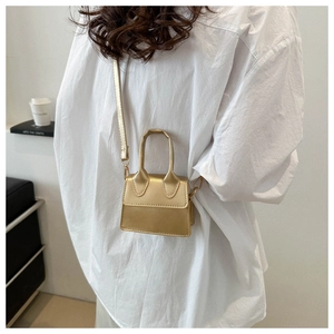Detaillierte Nahaufnahme einer goldenen Mini-Handtasche aus PU-Leder mit glänzender Oberfläche