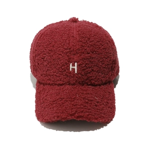 Détail de la casquette bordeaux en polaire peluche avec broderie H blanche