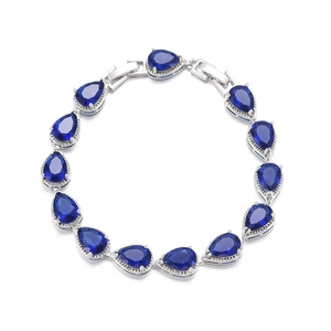 Detailed close-up of a silver-tone bridal bracelet with pear-cut deep blue cubic zirconia
