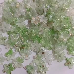Close-up of green and white five-petal resin beads with gold foil for DIY jewelry making