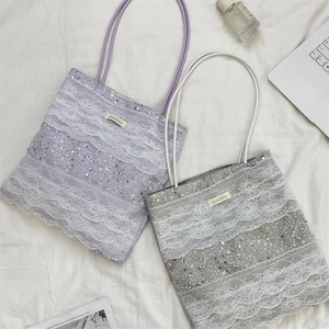 Détail du sac cabas en dentelle violette avec paillettes argentées et label Sojakka