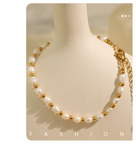 Detailed view of Baroque pearls and gold beads on a neck-mounted necklace display