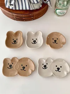 Close-up of cute bear-shaped ceramic dipping dishes in cream white and caramel brown glazes