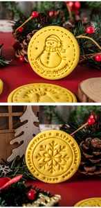 Close-up of yellow round Christmas cookies featuring snowman and snowflake stamped patterns