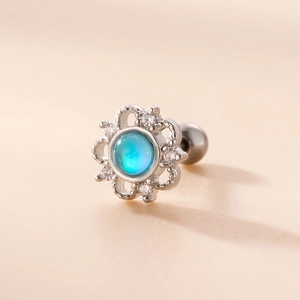 Macro shot of a silver flower ear stud with a blue opal center and zircon petals