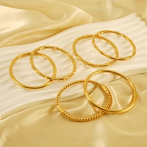 Set of six 18K gold-plated stainless steel bangles with bamboo and bead textures on silk