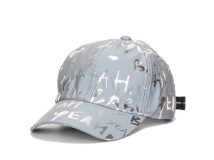 Detail of grey baseball cap showing silver reflective graffiti text and texture