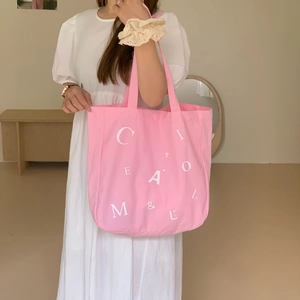 Detailaufnahme der rosa Canvas-Tragetasche mit weißem Buchstabendruck im Fotostudio