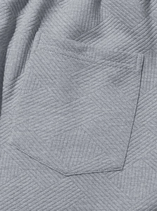 Gros plan sur la poche du sweat gris avec un tissu texturé jacquard géométrique en 3D