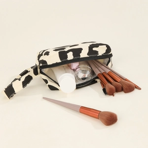 Large capacity canvas makeup bag with black and white cow print and cosmetic brushes