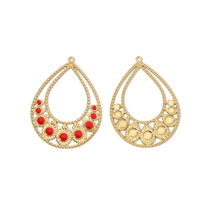 Macro detail of teardrop geometric metal pendants with red inlay and golden texture