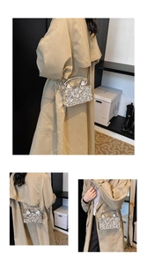 Detail of silver rhinestone acrylic evening bag with metal handle worn on a trench coat