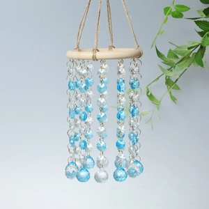Detail of crystal wind chime with light wood ring, blue octagonal beads and golden rings