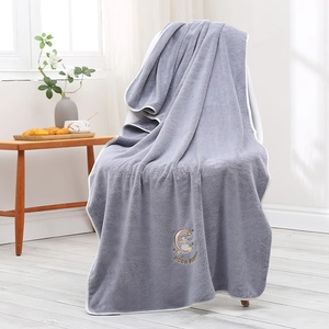 Close-up of grey coral fleece bath towel with Moon Rabbit embroidery and white piping