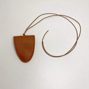 Détail du porte-lunettes en cuir marron à grain de litchi avec des coutures de précision