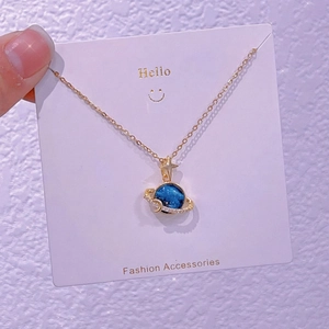 Dettaglio della collana con pendente a forma di pianeta blu e cerchio di zirconi lucidi
