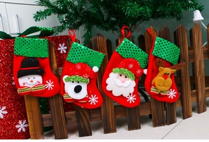 Detailed view of four sequin Christmas stockings hanging on a wooden fence decor