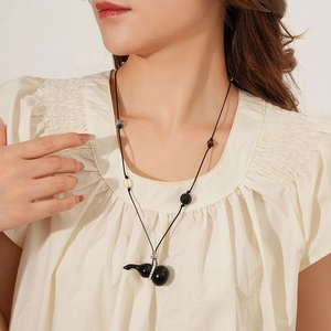 Detailed view of Zen-style necklace with wooden gourd pendant and assorted beads on model