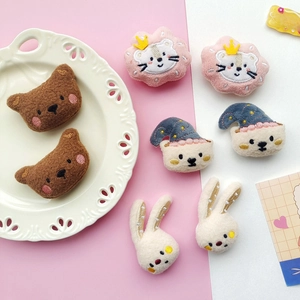 Close-up of assorted plush cartoon animal brooches with bear, cat and rabbit embroidery