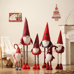Large plush Christmas gnome dolls in red and grey standing in a cozy living room scene